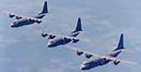 Three C-130J Hercules aircraft flying in formation.